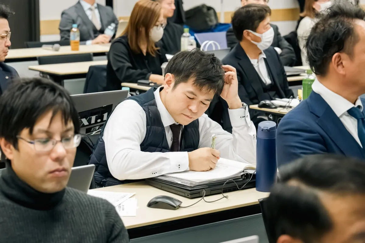講義を聞きながらノートを取るセミナー参加者